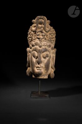 une tête de Bouddha sculptée posée sur un socle