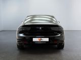 the rear end of a black sports car in a white room