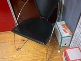 a black chair sitting in front of a red door