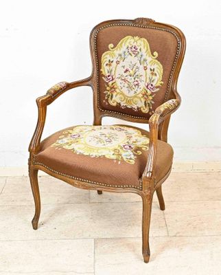 une chaise marron dont le dossier est recouvert d'un tissu à motifs floraux