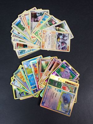 de nombreuses cartes Pokémon disposées sur une table noire