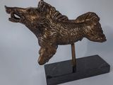 a bronze statue of a dog on a black marble base