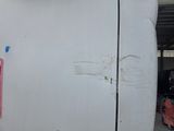 a white refrigerator that has been painted white and has a red tag on it