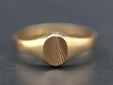 a close up of a gold ring with a shell in the middle