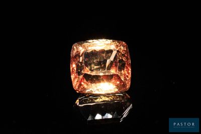 un diamant orange est représenté sur une surface noire