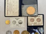 un assortiment de pièces d'or et d'argent, dont l'une se trouve dans un étui noir
