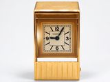 l'image d'une petite horloge dorée sur fond blanc