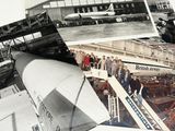 many pictures of a group of people standing in front of a plane