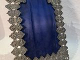 un cadre en argent richement décoré, recouvert de velours bleu