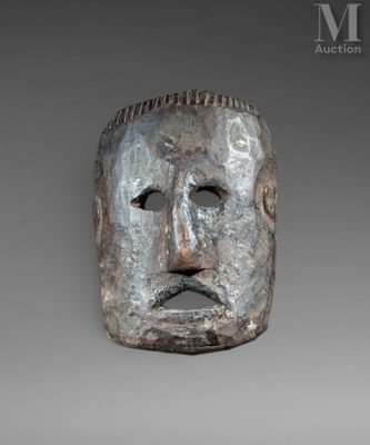 un gros plan d'un masque métallique sur fond gris
