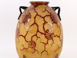 un vase jaune orné de fleurs marron sur fond blanc