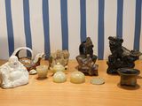 several figurines are sitting on a wooden table with blue and white striped wallpaper