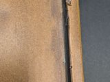 an old brown leather suitcase sitting on top of a black table