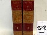 deux vieux livres posés l'un à côté de l'autre sur une surface blanche