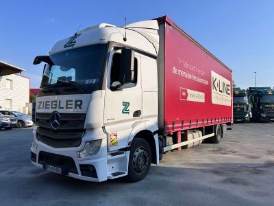 un camion rouge et blanc garé sur un parking