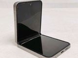 a black cell phone sitting on a white surface