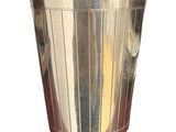 une tasse en métal posée sur une surface blanche