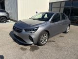 une voiture grise garée devant un immeuble, à côté d'autres voitures