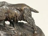 bronze statue of a goat and a sheepdog on a rock