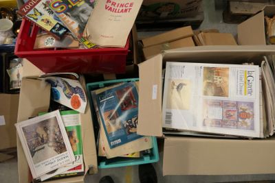 une boîte remplie de livres et de magazines posée par terre