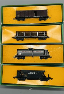 trois wagons de train miniature dans une boîte verte, posés sur une table