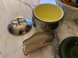 a cup of tea next to a bowl of cookies on a table