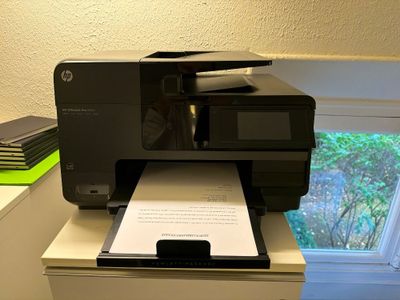 une imprimante posée sur un bureau près d'une fenêtre