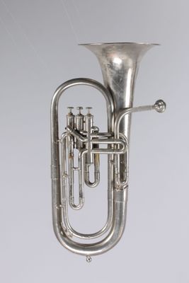 un instrument de musique ancien plaqué argent sur fond blanc