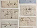 plusieurs vieux morceaux de papier couverts d'écriture, posés sur une table