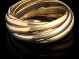 gros plan d'une bague en or sur une surface noire