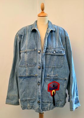 veste en jean avec une fleur rouge et bleue appliquée sur le devant