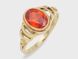 a close up of a gold ring with a red stone