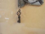 a small key hanging from a chain on a piece of cloth