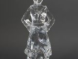 une figurine en verre transparent représentant un homme assis sur un rocher