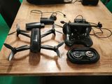 une table sur laquelle se trouvent une télécommande et un petit drone