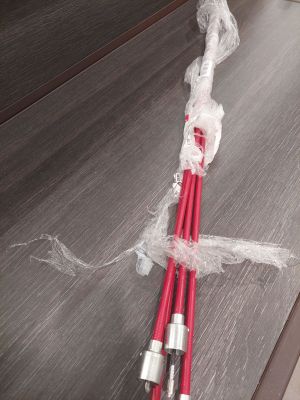 deux tuyaux rouges emballés dans du plastique, posés sur une table
