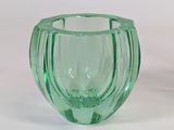 a green glass vase that is sitting on a table