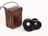 a brown leather case with a pair of binoculars next to it