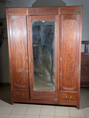 a wooden armoire with a mirror on top of it