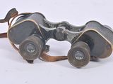 an old pair of binoculars sitting on top of a white surface