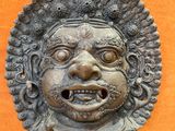 a close up of a statue of a face on an orange wall