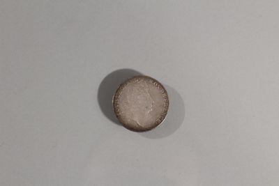 une pièce de monnaie posée sur une surface blanche