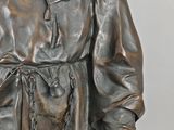 bronze statue of a monk with a chain around his neck