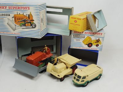 quatre camions miniatures et une boîte remplie de boîtes posés sur une table