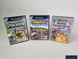 trois jeux Nintendo Wii posés sur une table blanche