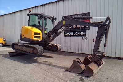 an image of a small excavator parked in front of a building