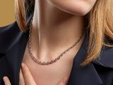 portrait of a woman in a black jacket with a chain around her neck