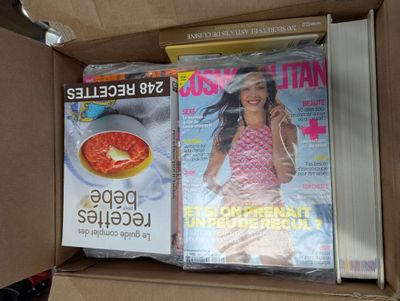 des magazines dans une boîte en carton avec une femme en couverture