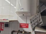 a tank on the wall of a kitchen that has a sign on it