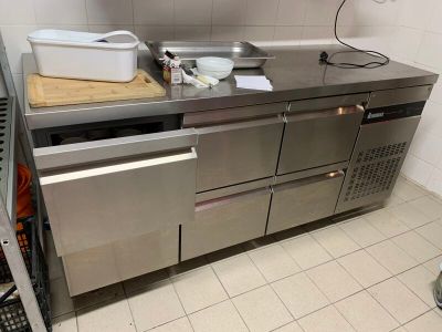 une grande cuisine en inox équipée d'un lave-vaisselle et d'un évier